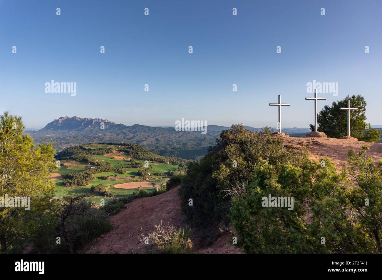 Frühling in Katalonien. Turó de les Tres Creus, Montserrat und die grünen Felder. Stockfoto