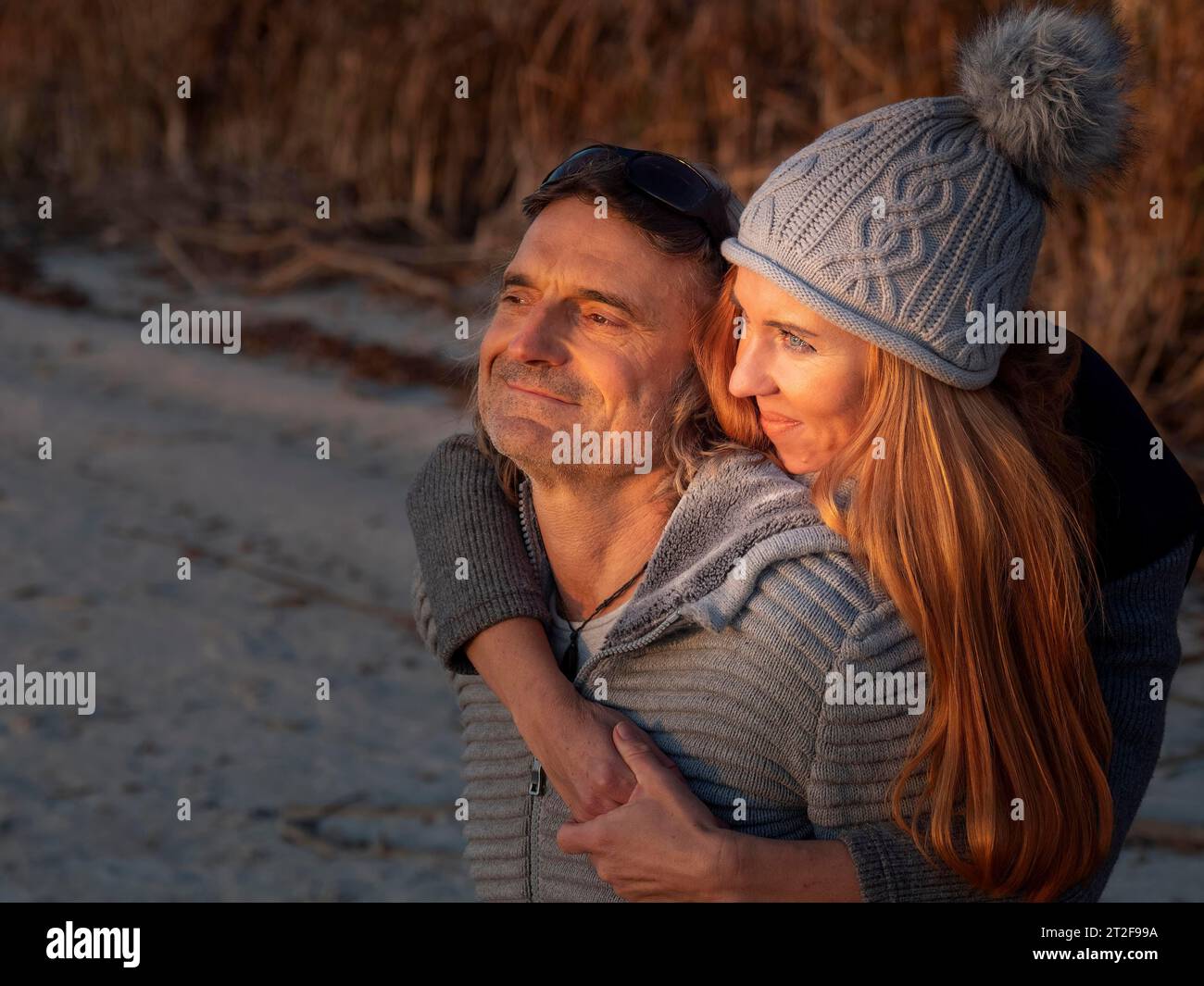 Intime Paare, die sich umarmen, Winterkleidung und Wackelhut in der Natur tragen, optimistische Sicht auf den Horizont, Vertrauen in Gottes Schöpfung, Deutschland Stockfoto