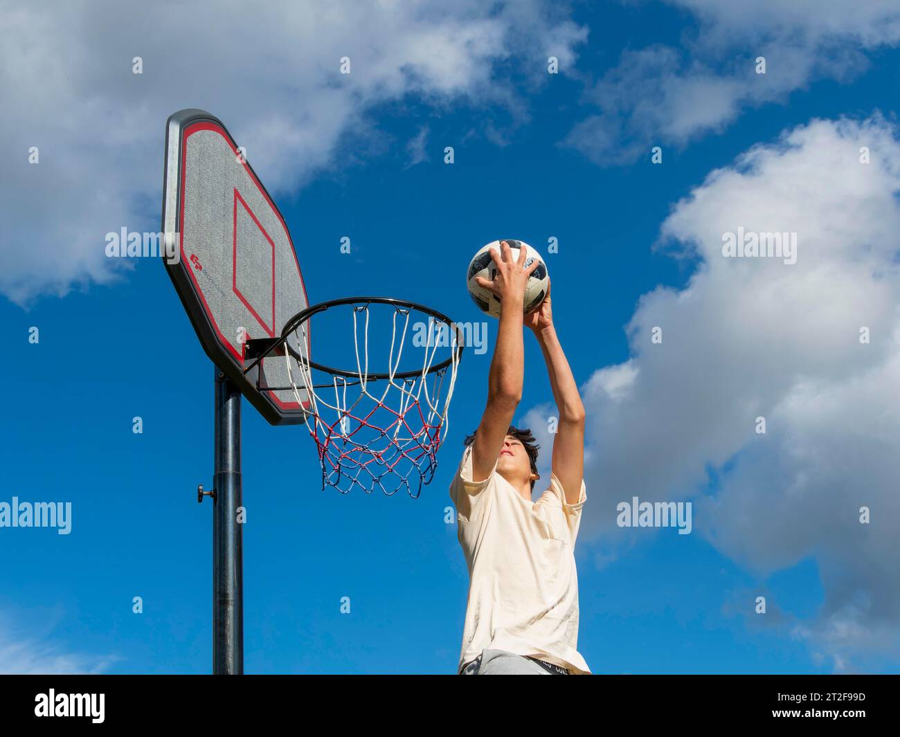 Basketballspringen mit dem Ball in den Korb und ins Netz, sportliche Aktivitäten mit Kindern, Deutschland Stockfoto