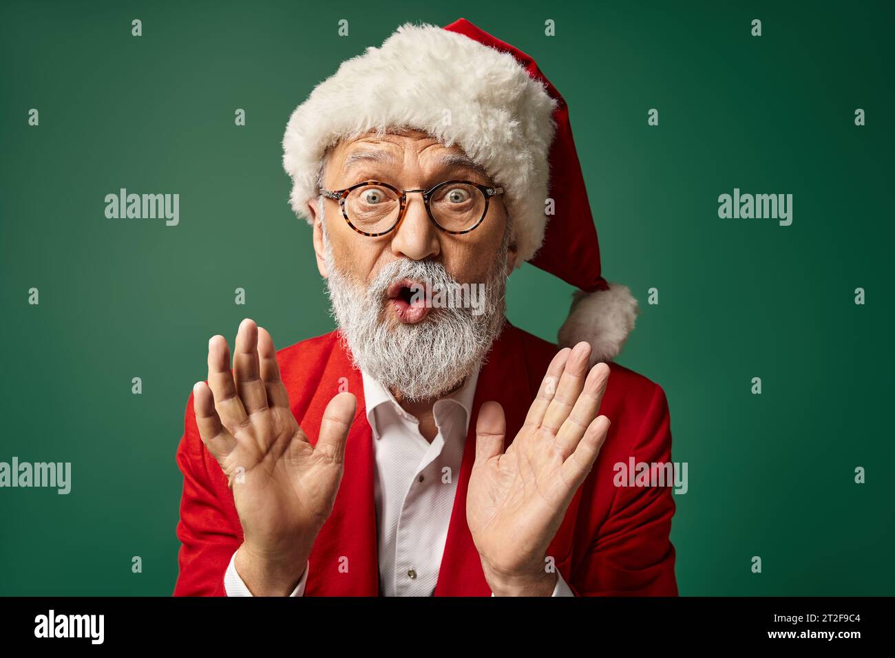 Verblüffter Weihnachtsmann mit weihnachtlichem Hut und Brille, Gesten mit leicht offenem Mund, Winterkonzept Stockfoto