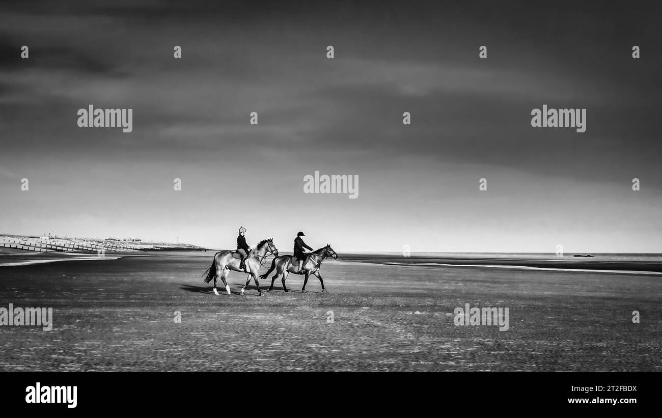 Camber Sands Beach, East Sussex, 11. April 2017, Reitreiter an einem englischen Strand bei Ebbe, Großbritannien Stockfoto