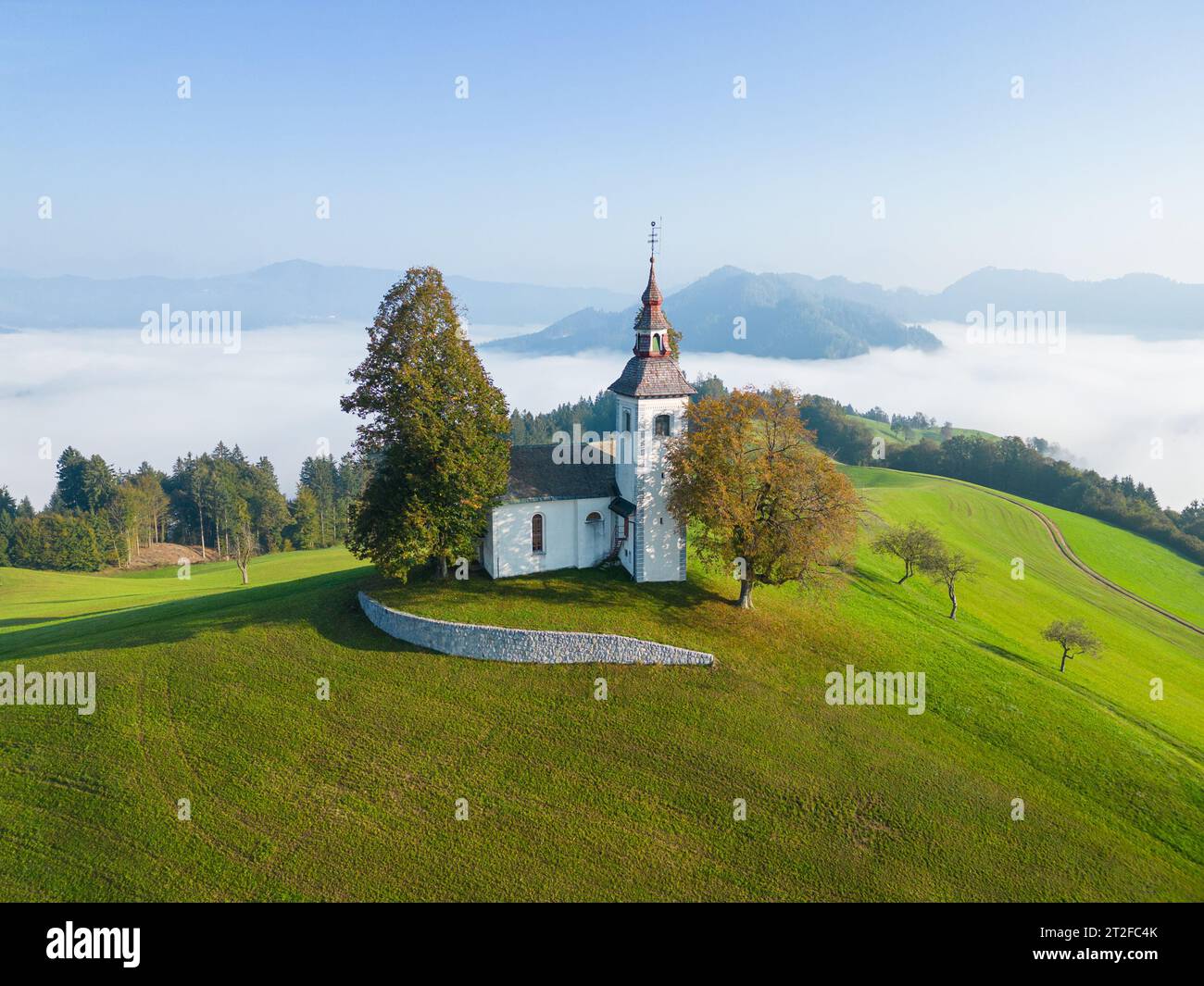 Luftdrohnenaufnahme der Kirche Sveti Tomaž in Škofja Loka in Slowenien am frühen Morgen Stockfoto