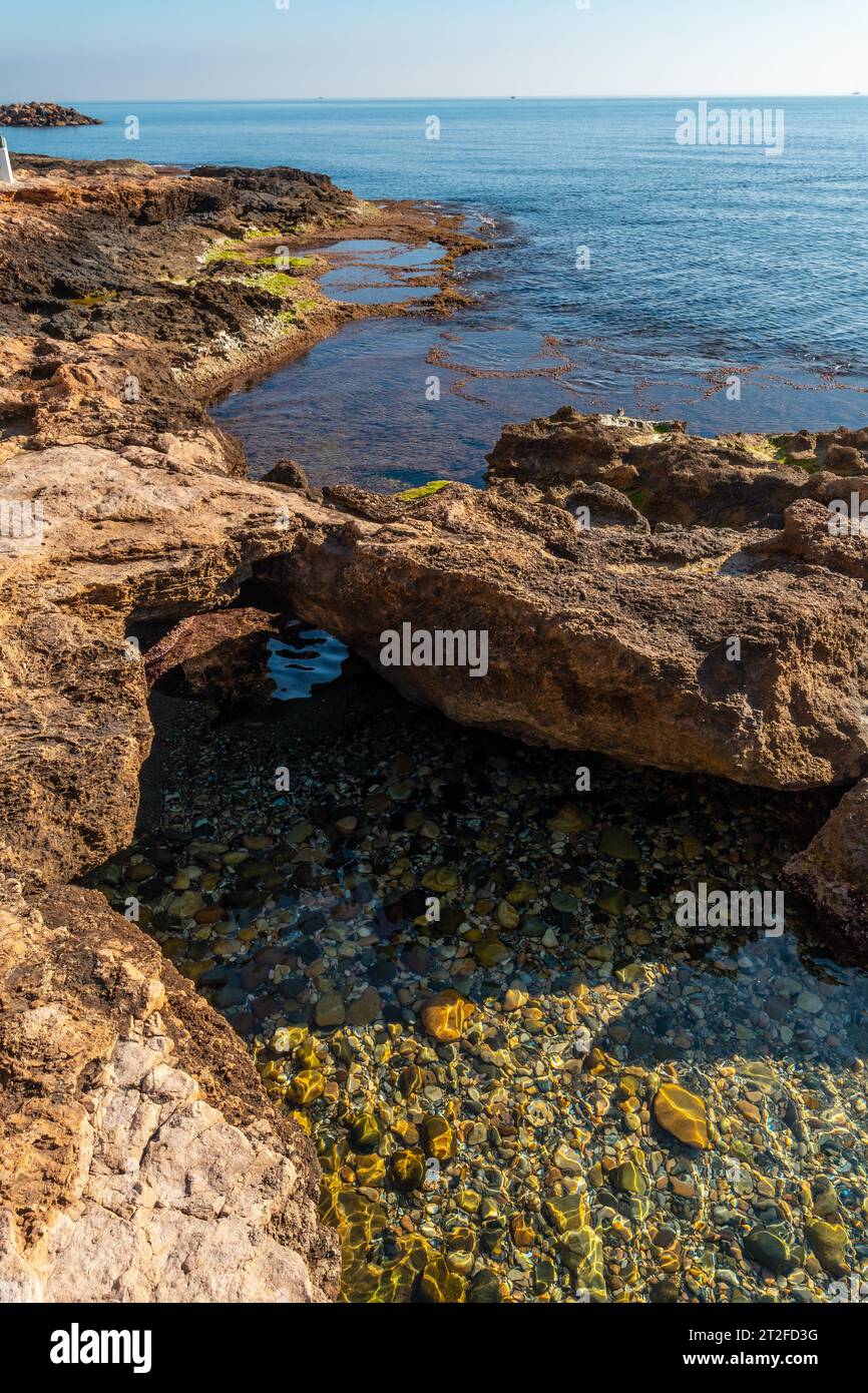 Kostbare Felsen am Meer in der Küstenstadt Torrevieja, Alicante, Valencianische Gemeinschaft. Spanien, Mittelmeer an der Costa Blanca Stockfoto