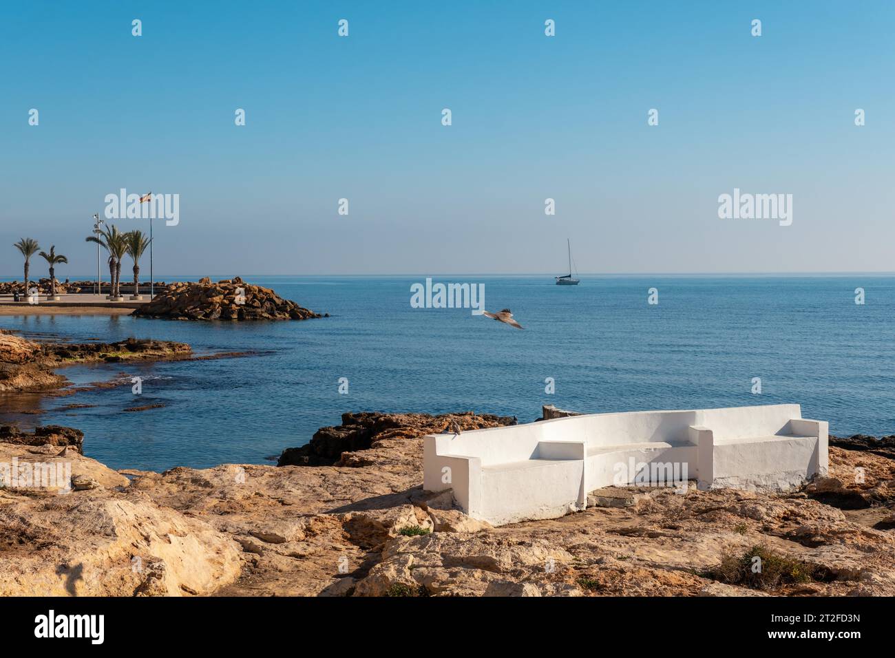 Ein weißer Sitz am Meer in der Küstenstadt Torrevieja neben Playa del Cura, Alicante, Valencianische Gemeinde. Spanien, Mittelmeer auf dem Stockfoto