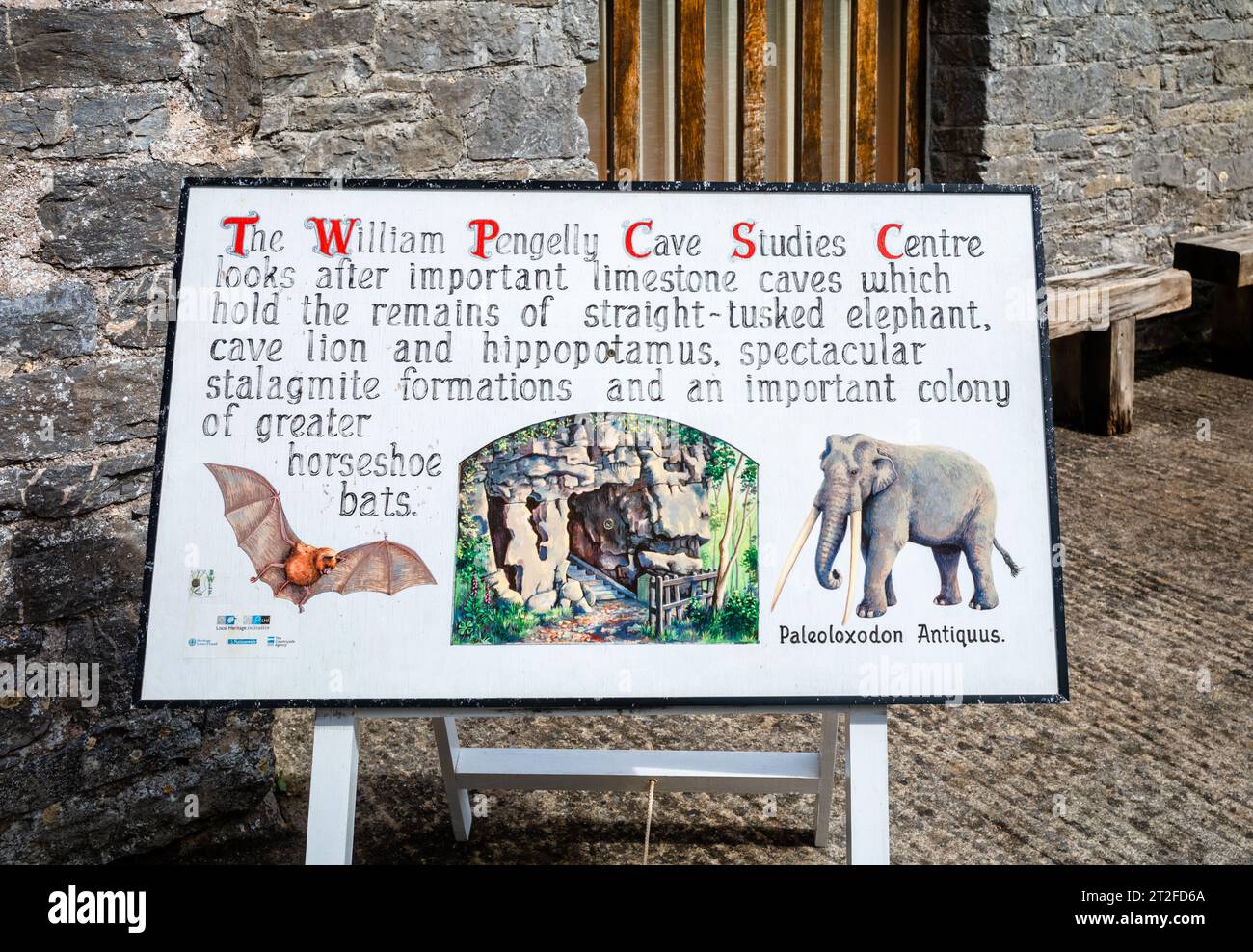 Ein weißes Schild mit Bildern einer Mamouth und einer Fledermaus, die die Rolle des William Pengelly Cave Studies Centre beim Schutz und Studium der alten Li beschreiben Stockfoto