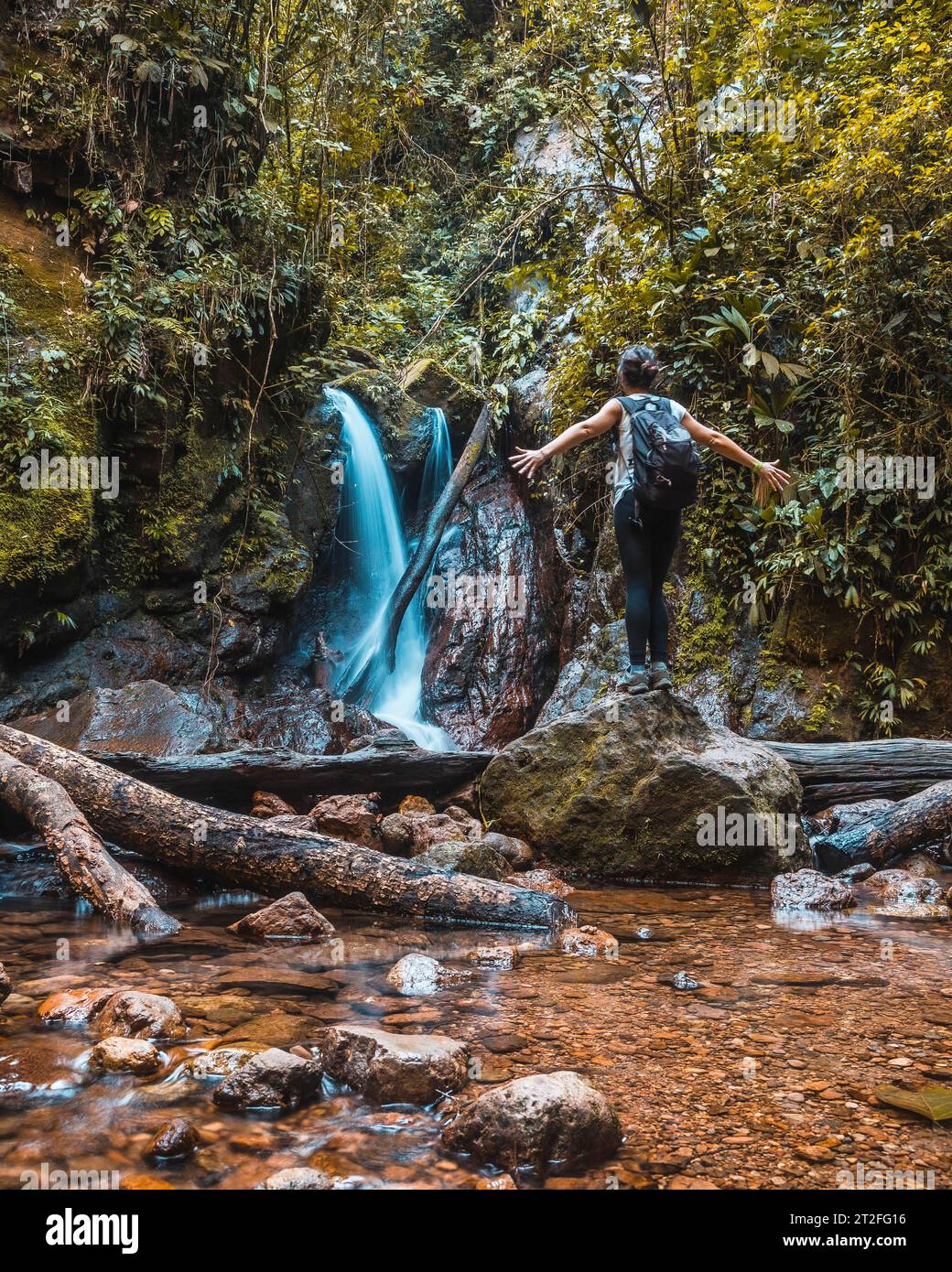 Eine junge Frau, die den natürlichen Wasserfall des Cerro Azul Meambar National Park (Panacam) in Yojoa genießt. Honduras Stockfoto