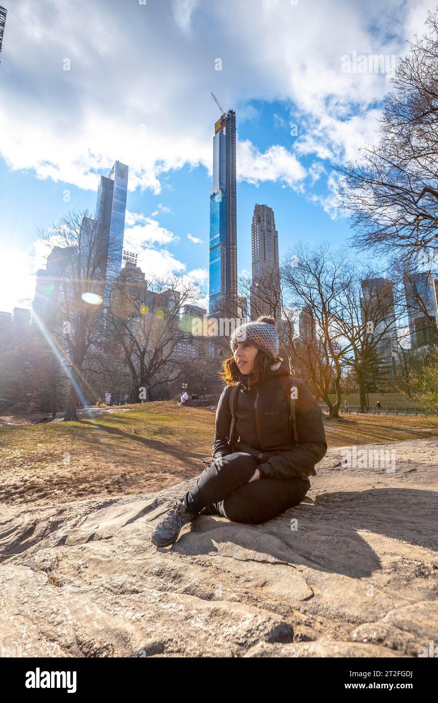 New York, United States Â», 5. Januar 2020: Ein junger, lächelnder Tourist sitzt im Winter im Central Park Stockfoto