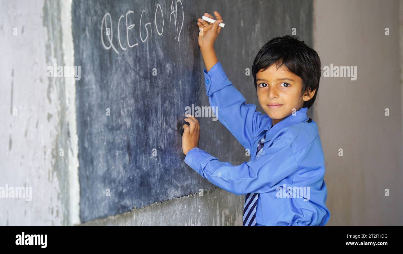 Indischer Schuljunge, der gegen leere Tafel steht, intelligenter und intelligenter Schüler, Bildungskonzept oder Back-to-School Stockfoto