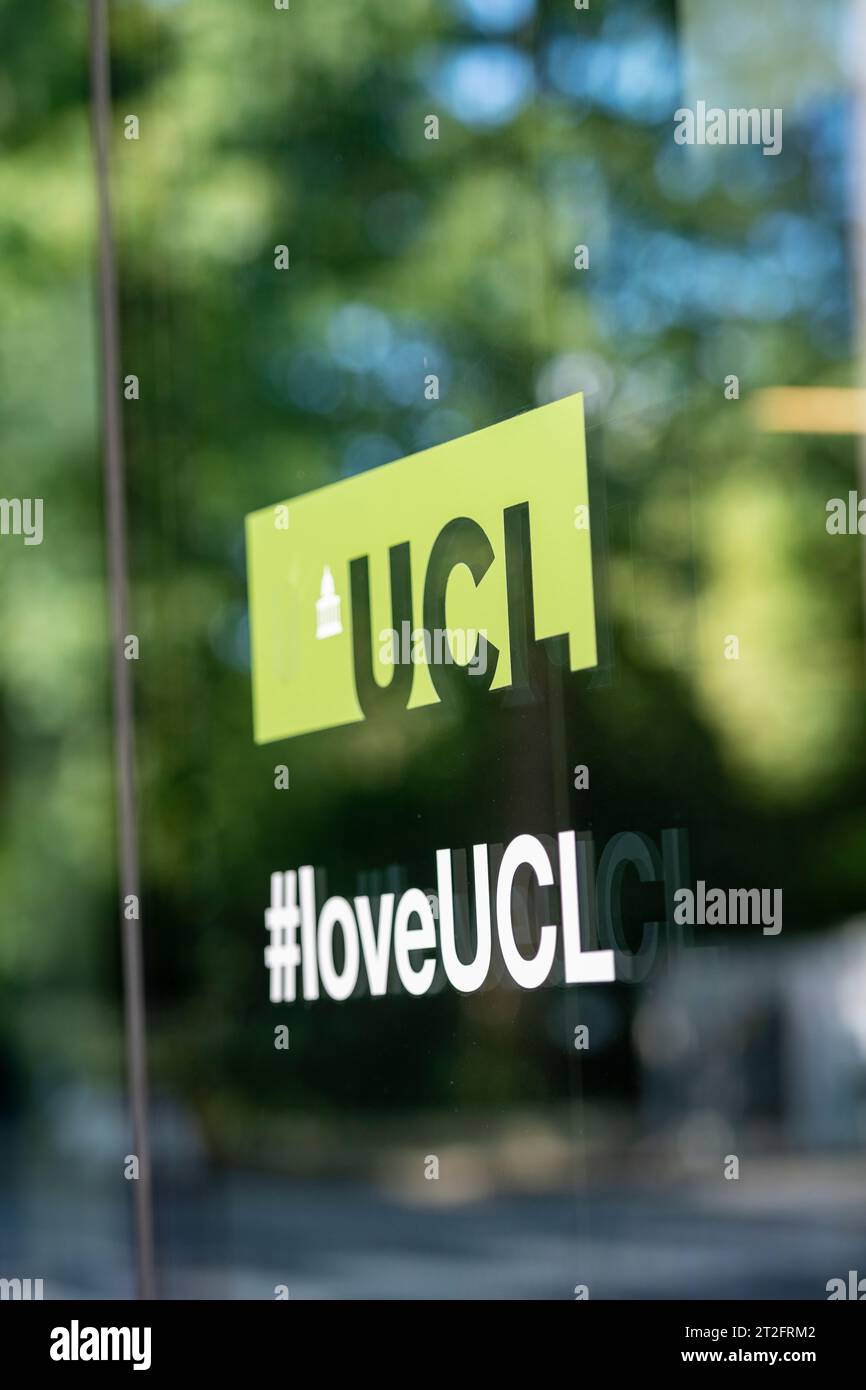 UCL-Zeichen und Hashtag spiegeln sich in einem Glasfenster auf dem Campus des University College London wider. Nur redaktionelle Verwendung. Stockfoto