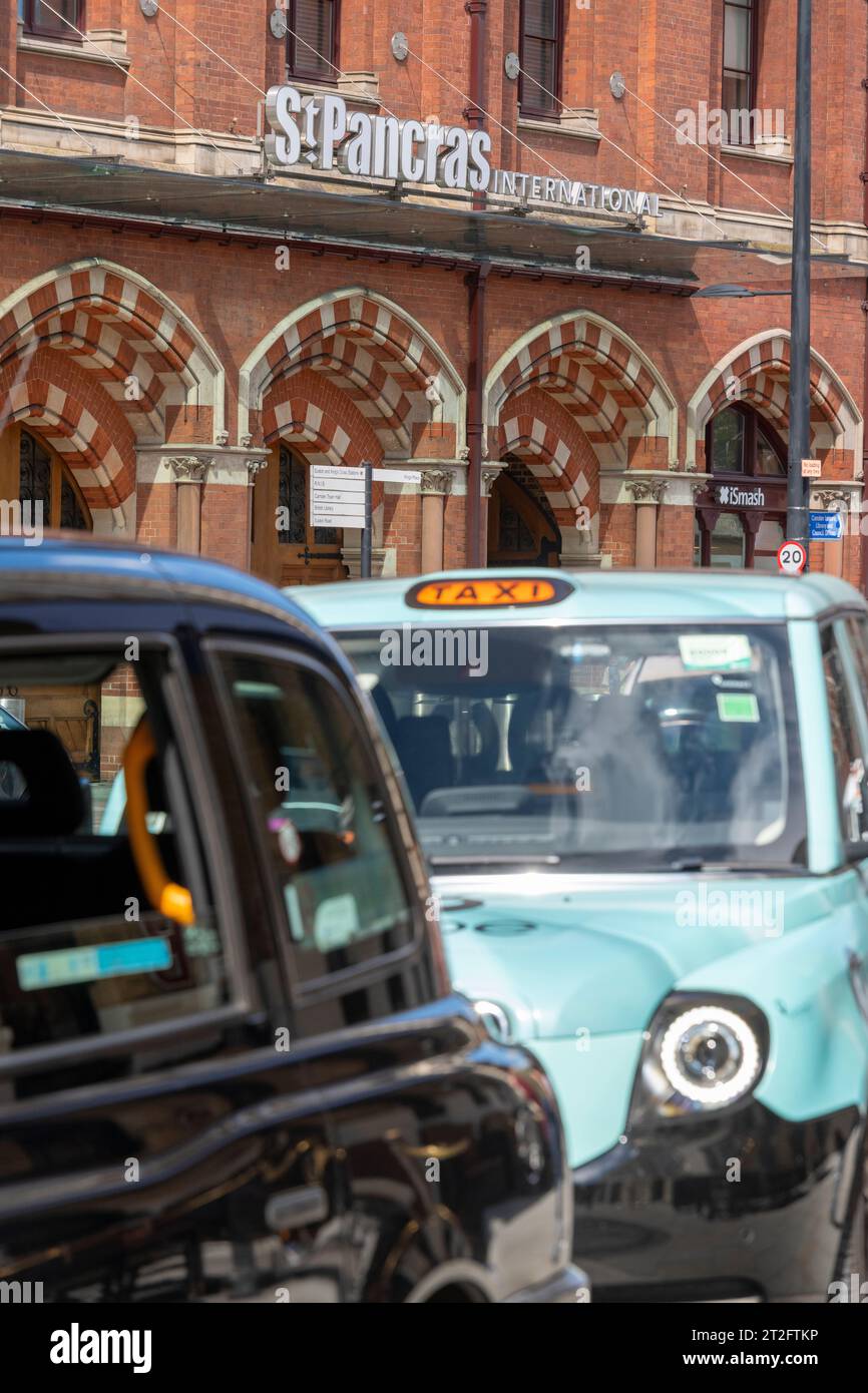 Schwarze Taxis vor dem St Pancras International in London mit der berühmten roten Backsteinfassade und Beschilderung des Bahnhofs. Nur redaktionelle Verwendung Stockfoto