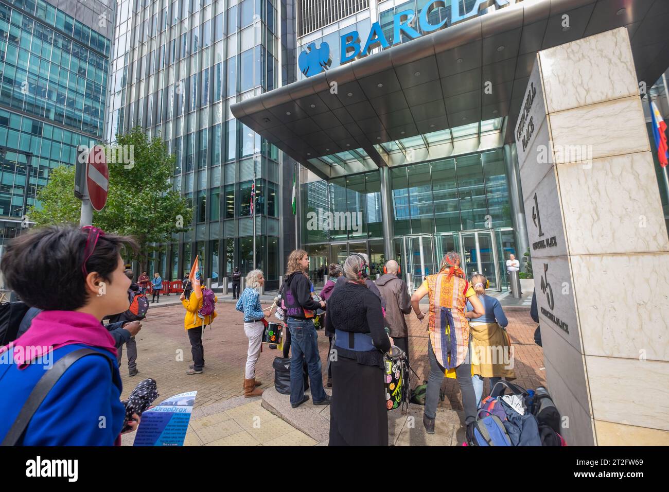 London, Großbritannien. Oktober 2023. Eine Frau hält an, um den Protest im Hauptquartier der Barclays Canary Wharf zu beobachten und fordert, dass sie die Unterstützung für Drax beenden, den weltweit größten Brenner von Bäumen, der jetzt etwa 2 Millionen Pfund pro Tag an britischen Klimasubventionen für erneuerbare Energien für sein stark umweltschädliches Kraftwerk erhält. und fordert zusätzliche Subventionen für einen unbewiesenen und undurchführbaren Klimabedingbetrug zur CO2-Abscheidung. Drax verbrennt Holzpellets, die hauptsächlich durch klares Fällen reifer Bäume in den USA hergestellt werden. Peter Marshall/Alamy Live News Stockfoto