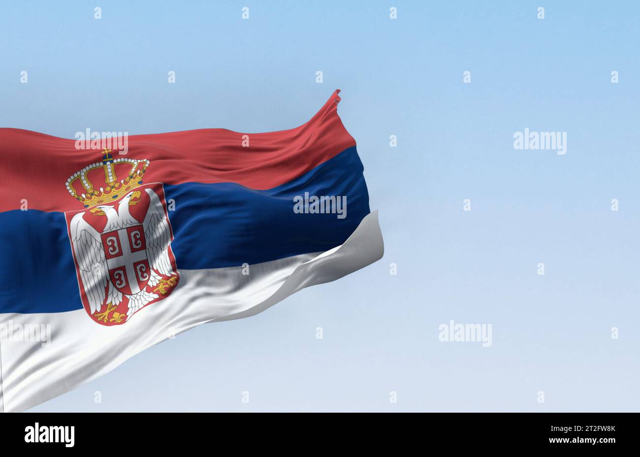 Die serbische Nationalflagge weht an einem klaren Tag im Wind. Rote, blaue und weiße Bänder, mit serbischem Wappen links von der Mitte. 3D-Illustration Stockfoto