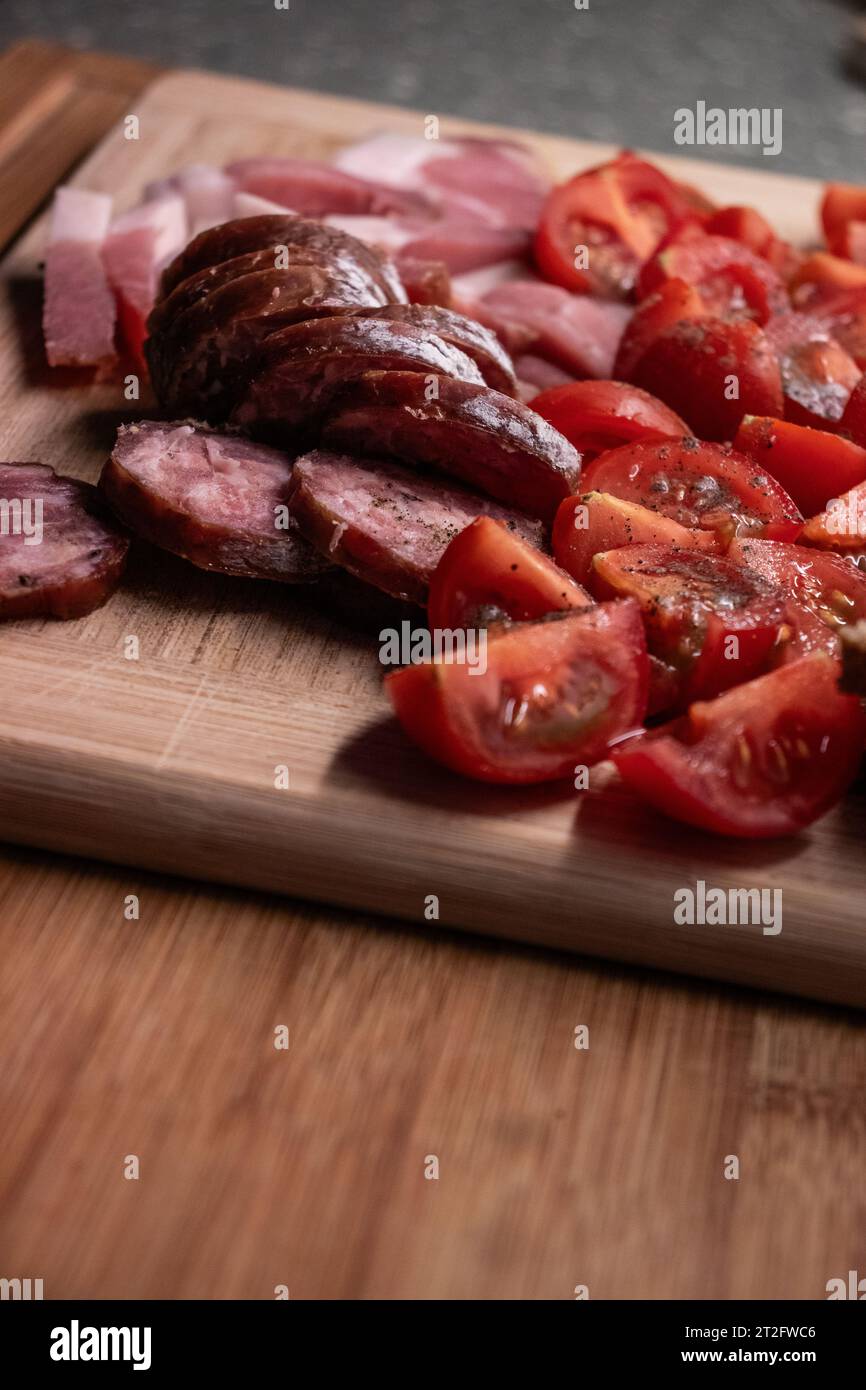 Blick von oben auf Tomaten. wurst, Brot, Schinken mit Salz und Paprika Stockfoto