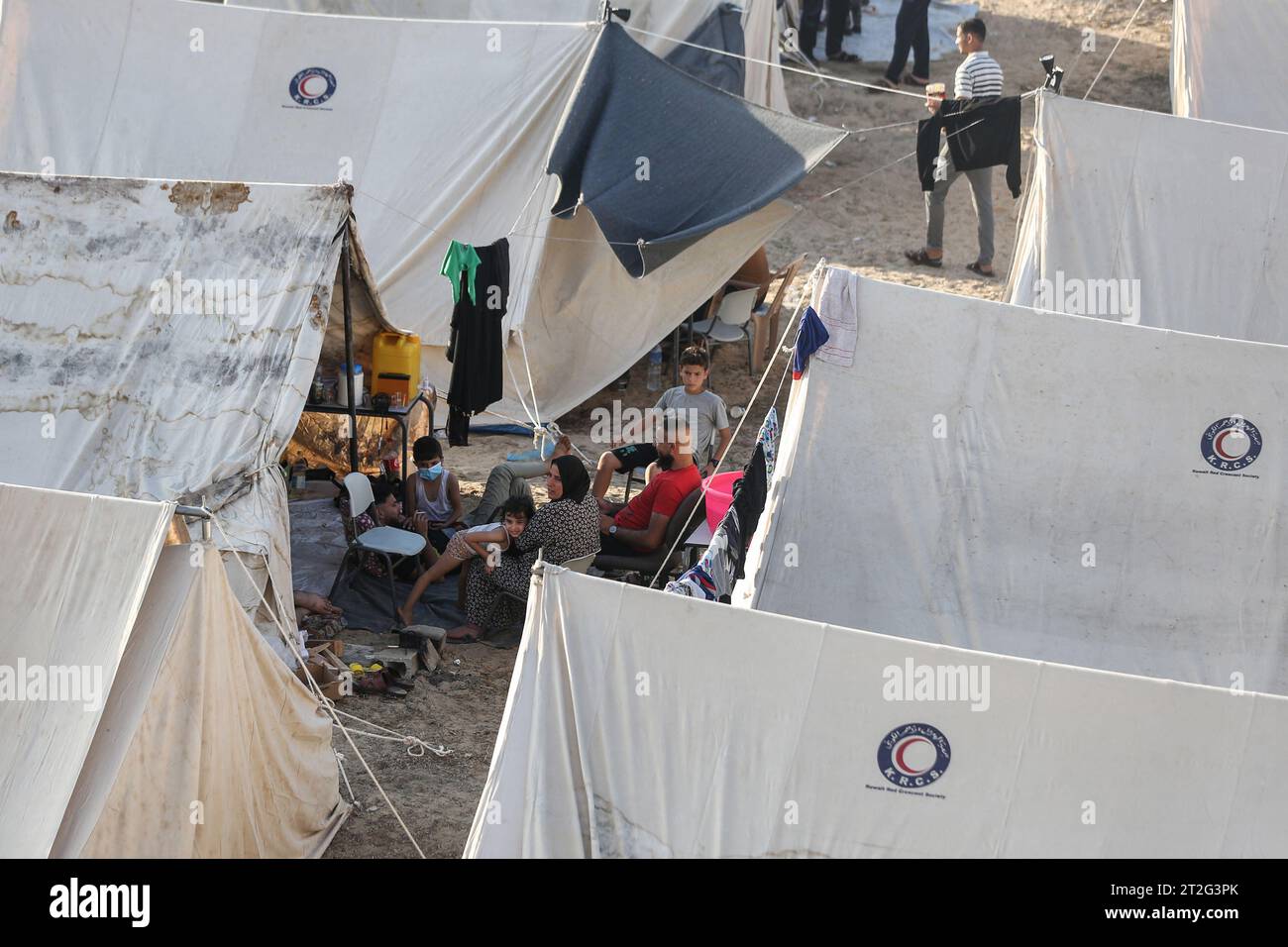 Khan Yunis, Palästinensische Gebiete. Oktober 2023. Menschen sitzen zwischen Zelten für Palästinenser, die Zuflucht suchen, die auf dem Gelände des Hilfswerks der Vereinten Nationen für Palästinaflüchtlinge (UNRWA) in Khan Yunis im südlichen Gazastreifen errichtet wurden. Quelle: Mohammed Talatene/dpa/Alamy Live News Stockfoto