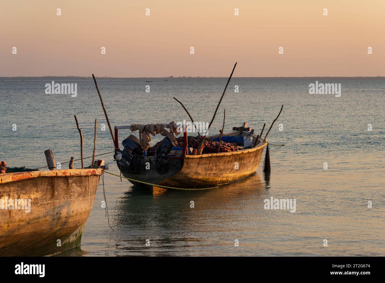 Angeln von Holzbooten, die am Strand wegen Ebbe bei Sonnenuntergang vor Angeln liegen, Sansibar, Tansania Afrika Stockfoto