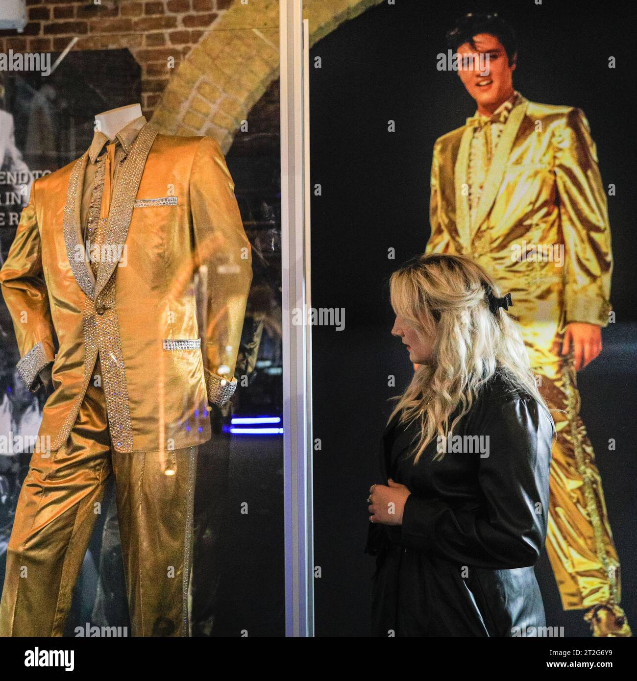 London, Großbritannien. Oktober 2023. Ein Besucher schaut sich den maßgeschneiderten Anzug „Gold Lame“ an, der für „Golden Boy“ Elvis entworfen wurde. Getragen auf dem Cover von '50.000.000 Elvis Fans Can't Be Wrong - Elvis' Gold Records Volume 2'. Die Ausstellung „Direct From Graceland: Elvis“ zeigt über 400 Artefakte und ikonische Gegenstände, die Elvis gehört, direkt aus dem Haus des Ikons in Graceland in Memphis, Tennessee. Die Ausstellung wird am 20. Oktober in der Arches London Bridge in der Bermondsey Street eröffnet. Quelle: Imageplotter/Alamy Live News Stockfoto