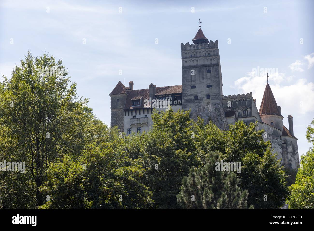 Mittelalterliches Schloss Bran (Castelul Bran), bekannt als Draculas Burg, in Bran, Siebenbürgen, Rumänien, hinter grünen Bäumen Stockfoto