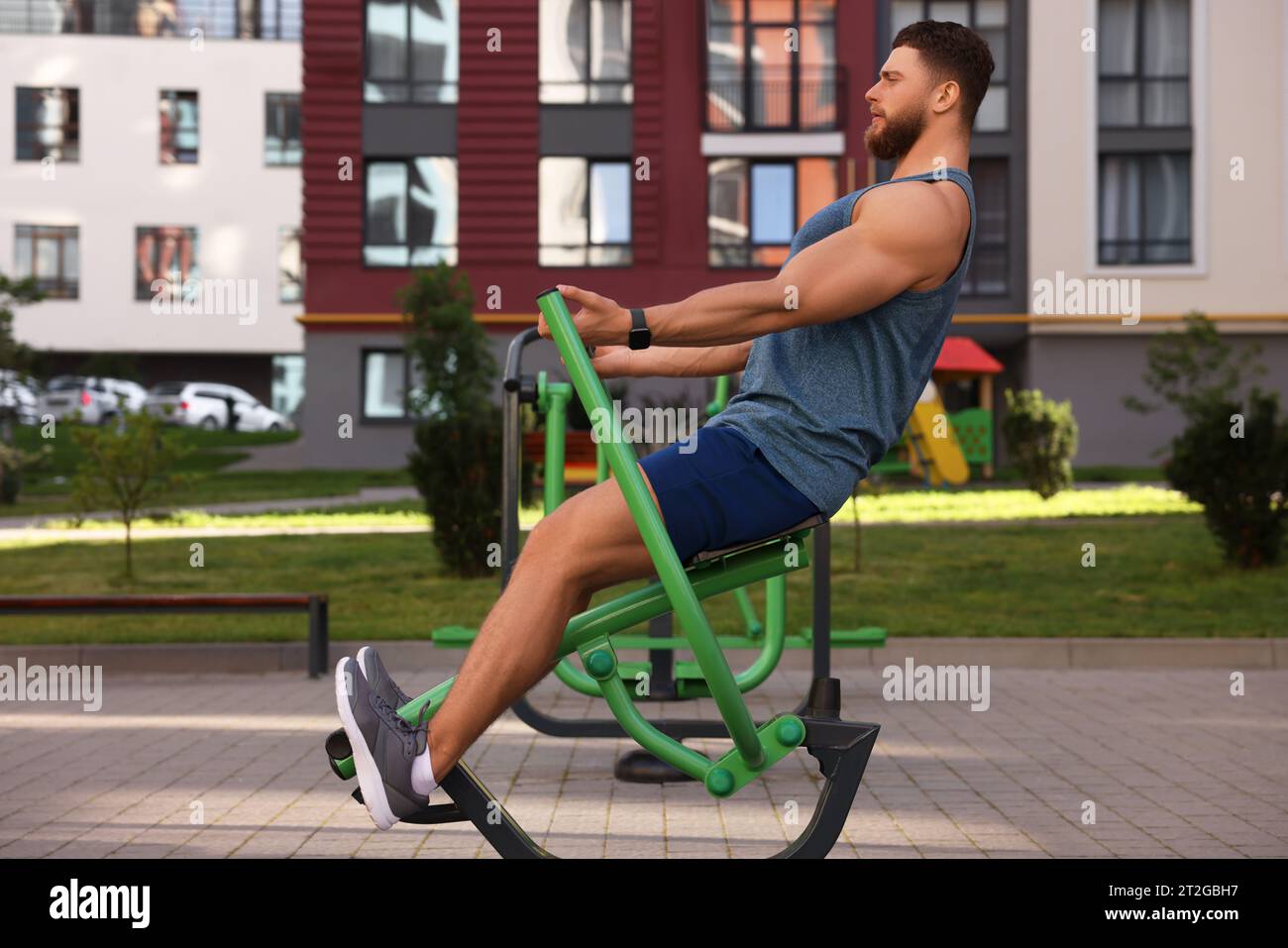 Mann trainiert am Rudergerät im Fitnessstudio im Freien Stockfoto