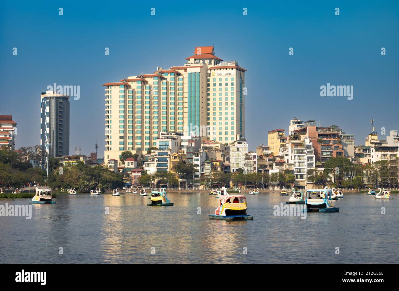 Auf dem Truc Bach Lake neben dem Pan Pacific Hotel in Hanoi, Vietnam, fahren die Menschen schwanförmige Tretboote Stockfoto