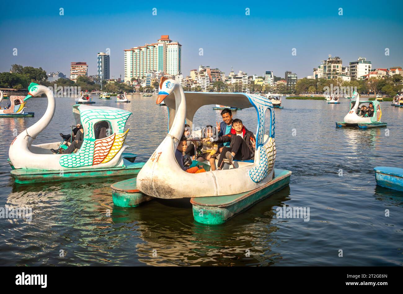 Ein vietnamesischer Vater mit vier kleinen Kindern auf einem schwanenförmigen Tretboot auf dem Truc Bach See, Hanoi, Vietnam Stockfoto