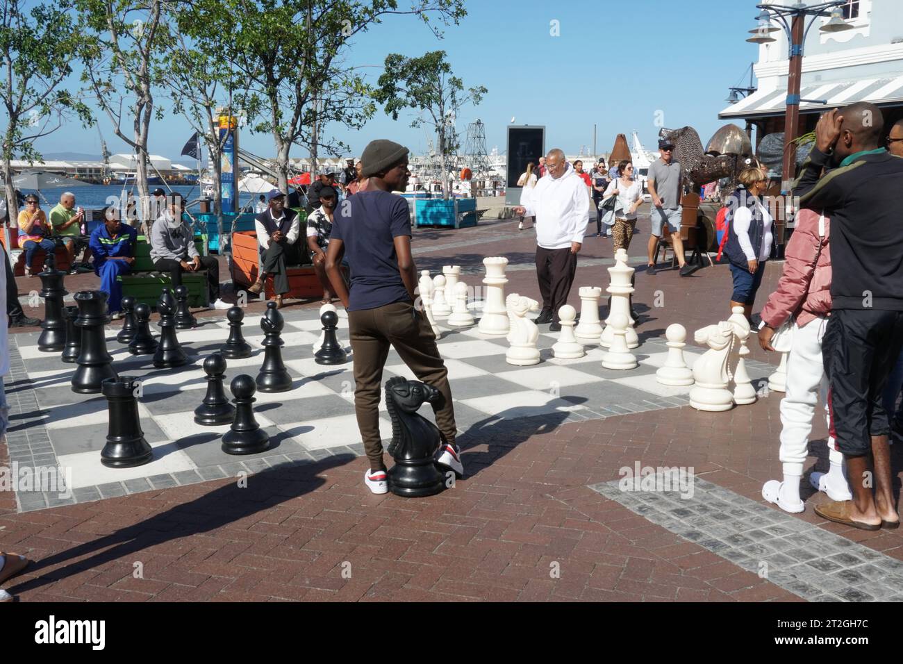 Lokale Spieler von Straßenschach genießen ein Spiel mit riesigen Schachmännern an der Waterfront in Kapstadt Südafrika. Stockfoto