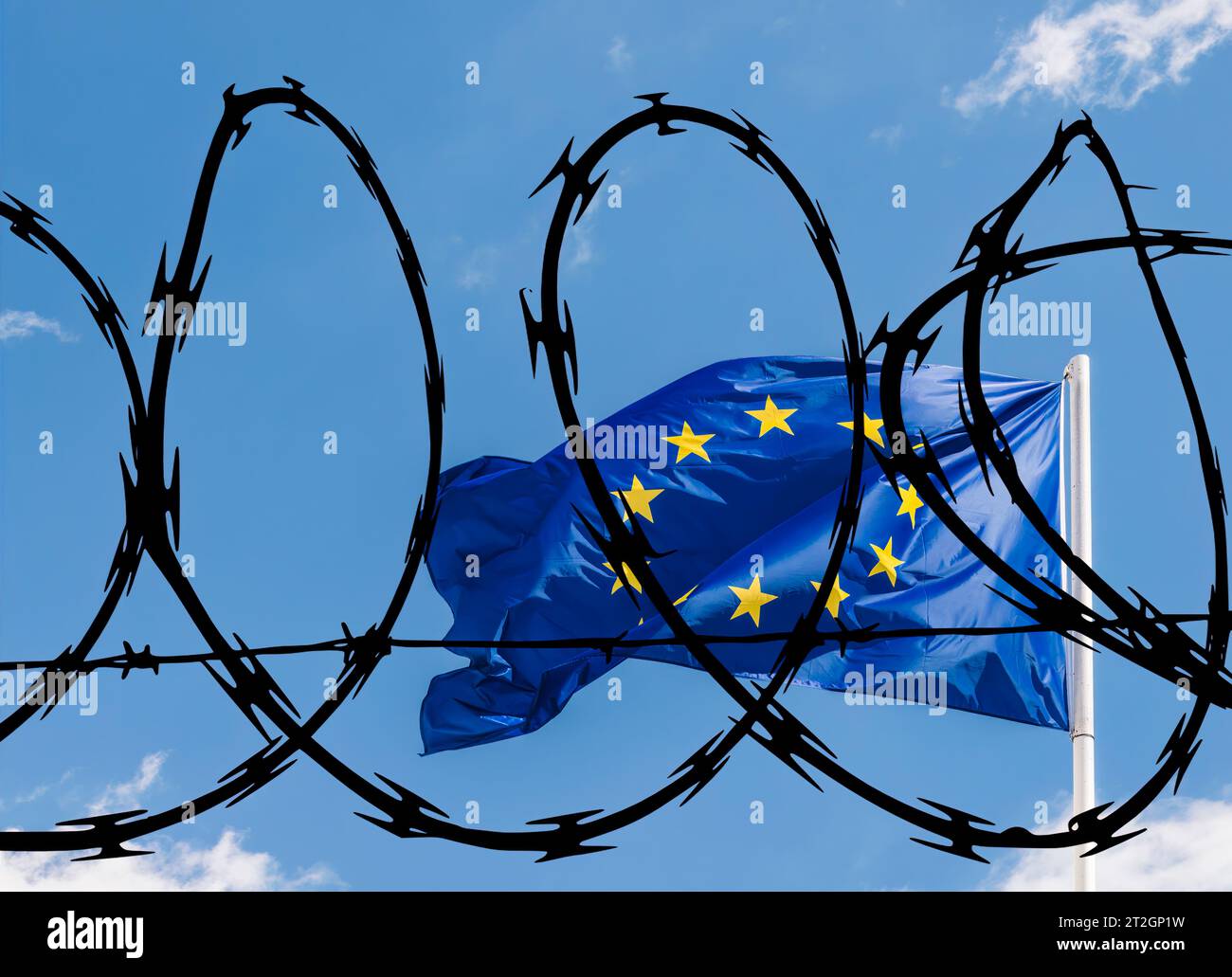 EU-Flagge vor blauem Himmel, überlagert mit Stacheldraht, der sich auf einen möglicherweise abgesperrten Block für nicht-EU-Bürger, einschließlich Flüchtlinge, bezieht Stockfoto
