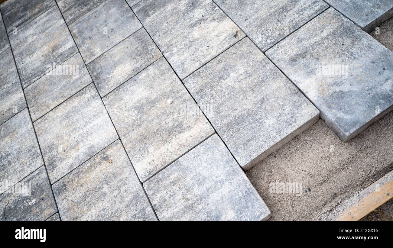 Unbehandelter Außenboden oder Bürgersteig mit Zementfliesen gepflastert. Bau im Porgess. Stockfoto