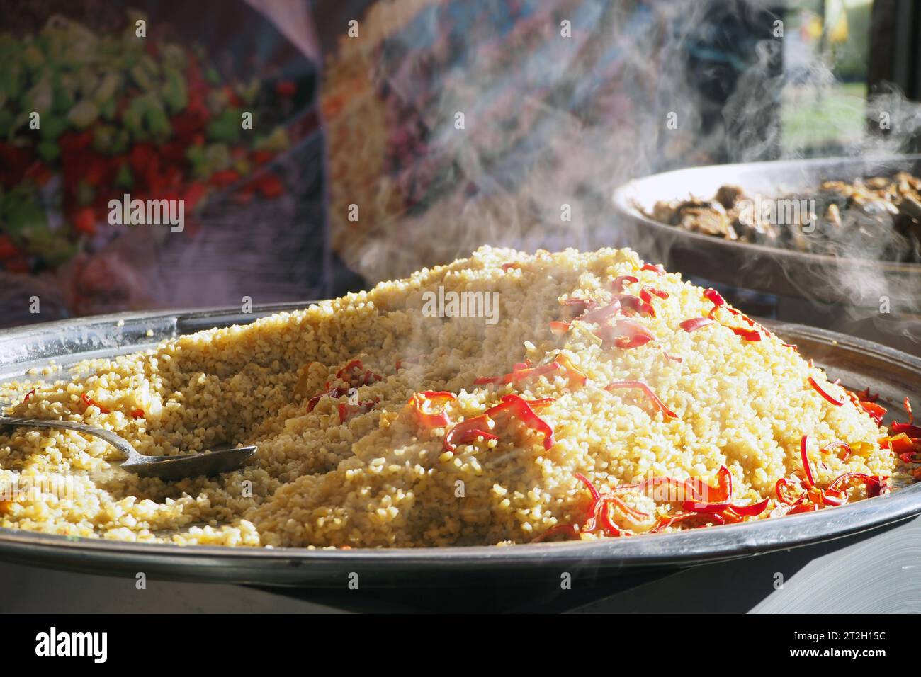 Frisch gebackenes Bulgur Pilaf. Rauch über Bulgur-Reis auf einem großen Tablett. Stockfoto