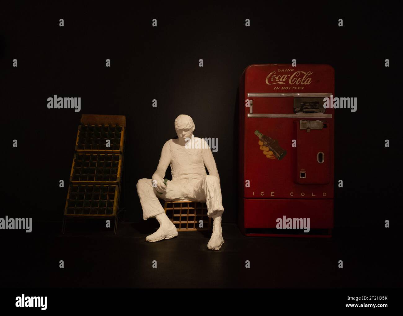 Eine Kunst, die einen Lieferer mit einem alten Coca-Cola-Automaten zeigt. Stockfoto