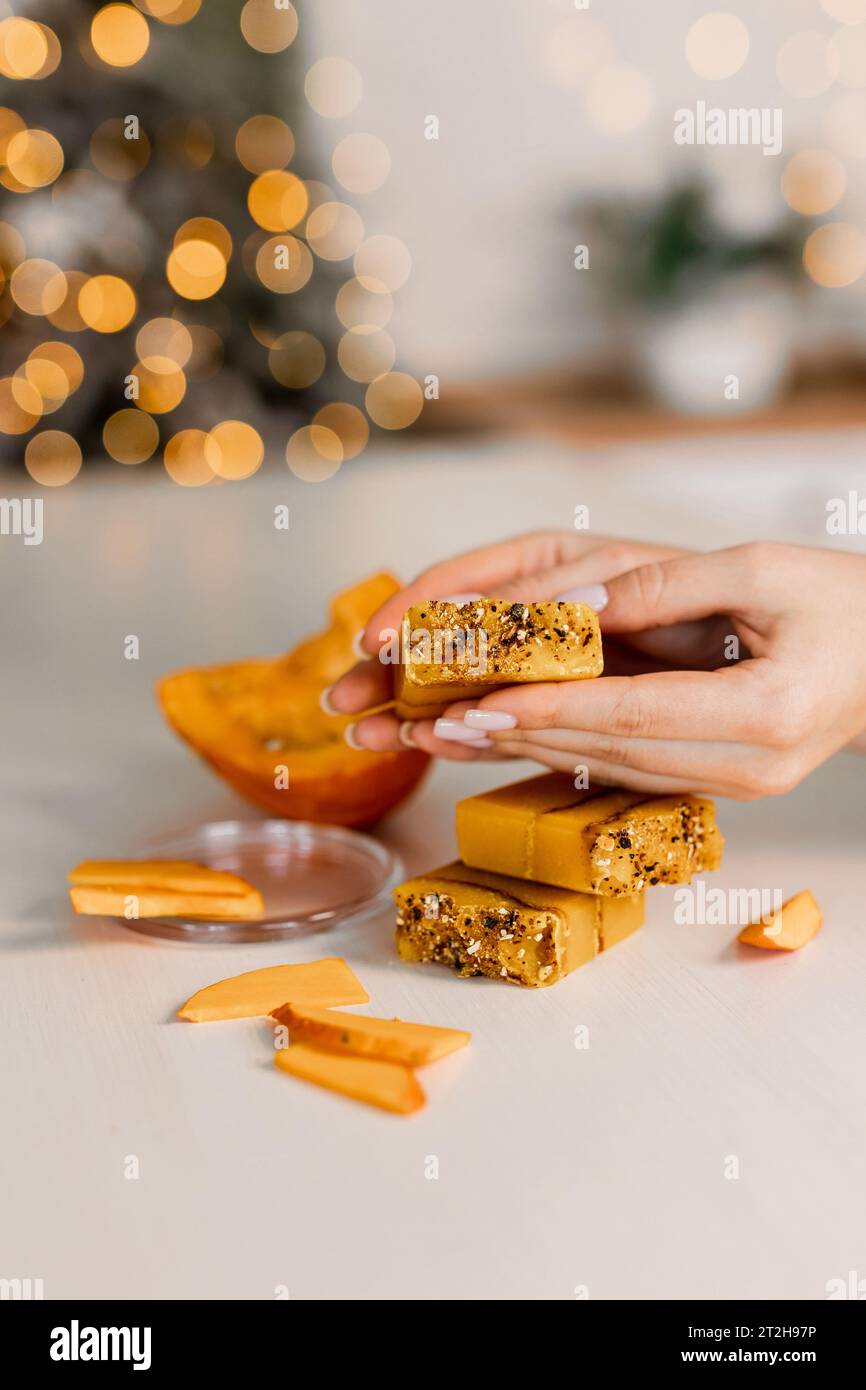 Weihnachts-Mockup-Konzept Kürbissnacks auf weißem Hintergrund. In Scheiben geschnittene ​​pumpkin in einem Tablett und Neujahrsdekor Stockfoto