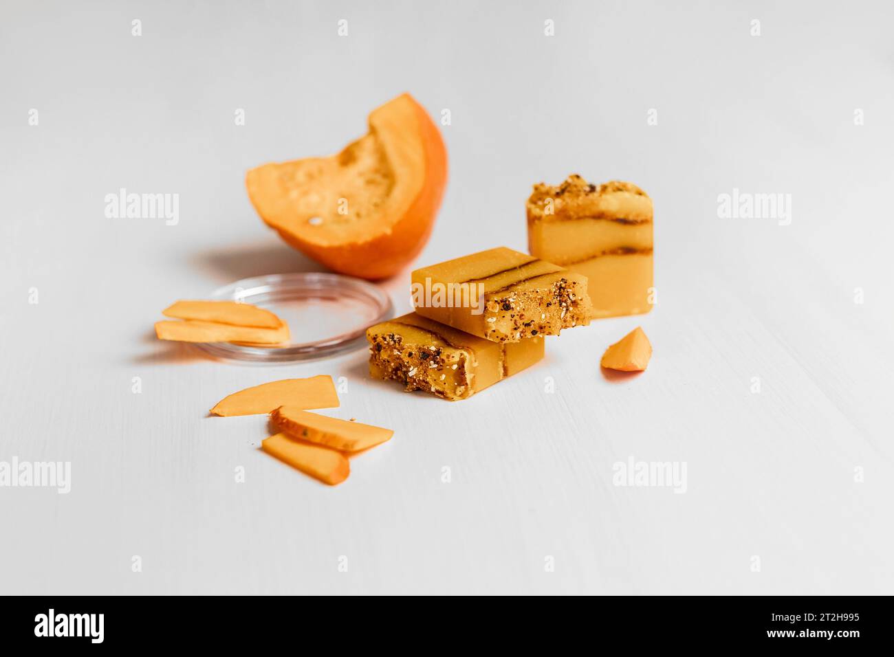 Mockup-Konzept Kürbissnacks auf weißem Hintergrund. In Scheiben geschnittene ​​pumpkin in einem Tablett und Neujahrsdekor Stockfoto