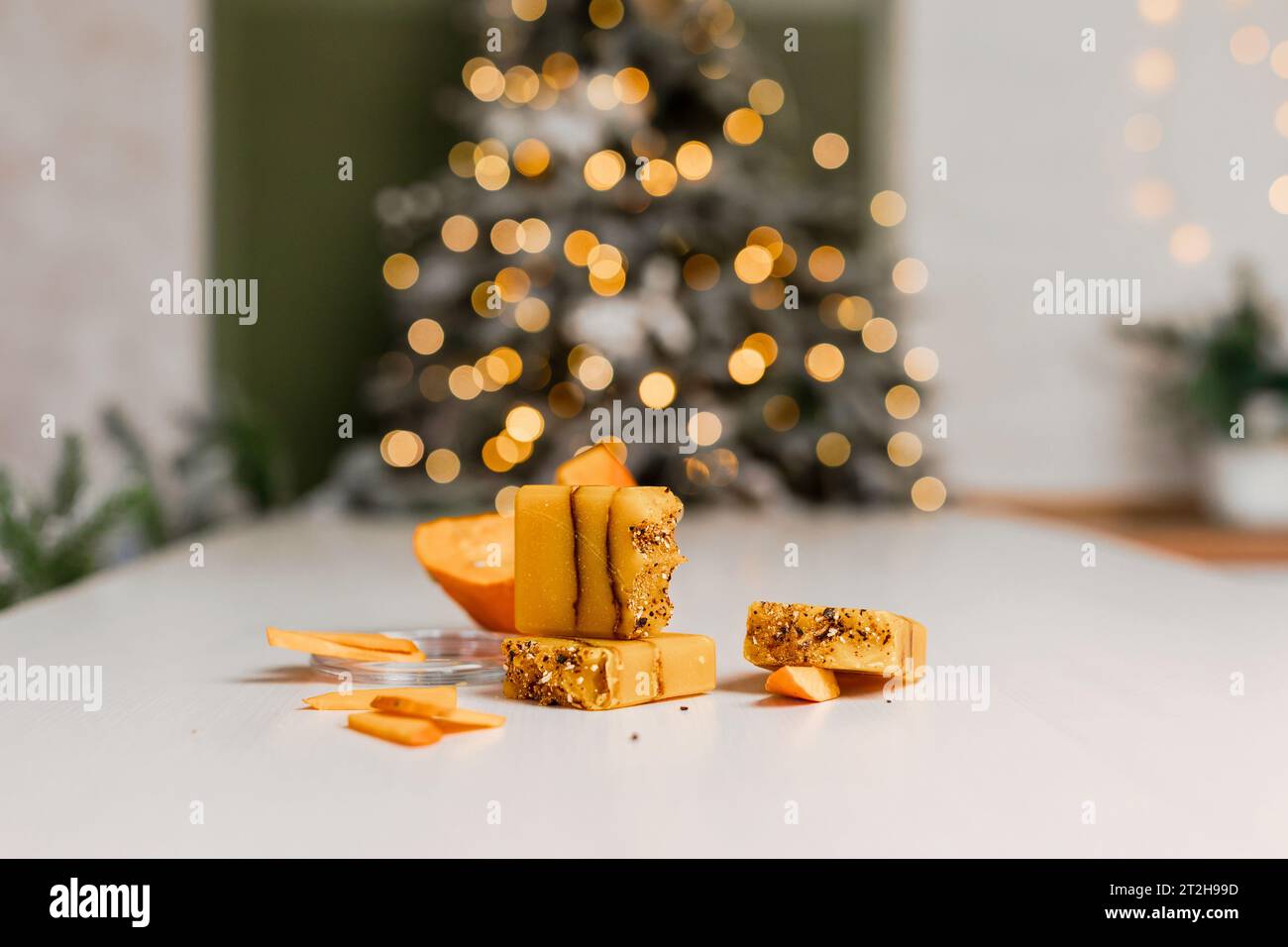 Weihnachts-Mockup-Konzept Kürbissnacks auf weißem Hintergrund. In Scheiben geschnittene ​​pumpkin in einem Tablett und Neujahrsdekor Stockfoto