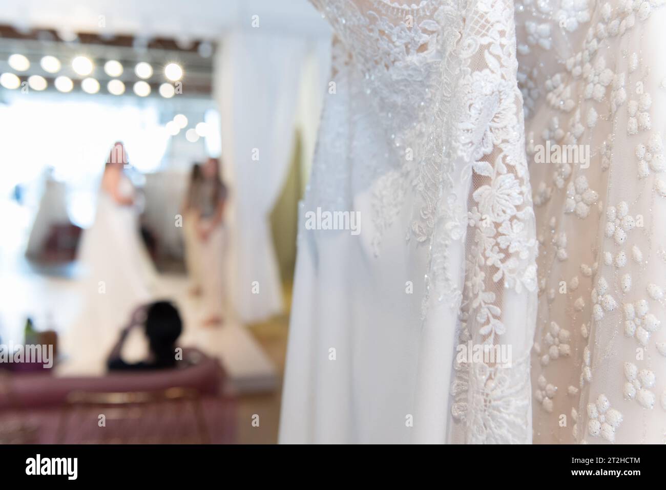 Braut, um verschiedene Brautkleider anzuprobieren, um zu sehen, welcher Spitzenstil am besten aussieht. Stockfoto