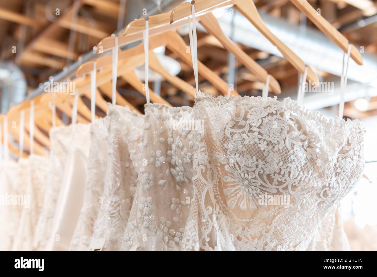In dieser Boutique stehen viele verschiedene Größen und Muster von Brautkleidern zur Auswahl. Stockfoto