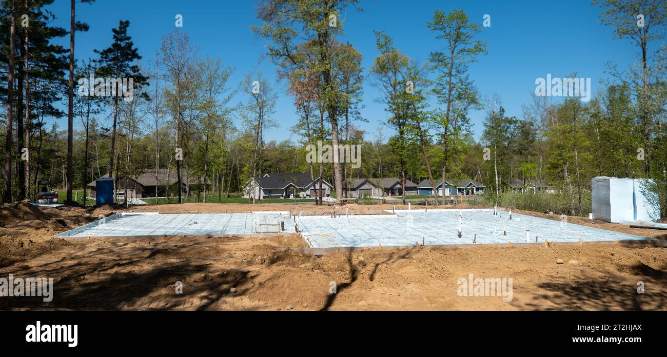 CROW WING CO, MN - 10 MAI 2023: Schönes bewaldetes Baugrundstück ist eine Baustelle mit Dämmung über dem Betonboden, an einem sonnigen Tag Stockfoto