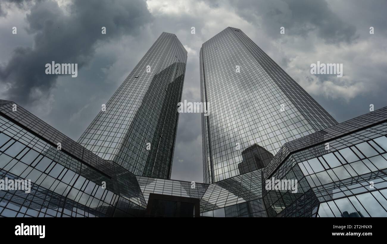 Die Zwillingstürme der Deutschen Bank, während dunkle Wolken vorbeiziehen (Hauptquartier). Finanzgeschäft in Deutschland. Bankunterschrift. Bankbranche in Frankfurt Stockfoto
