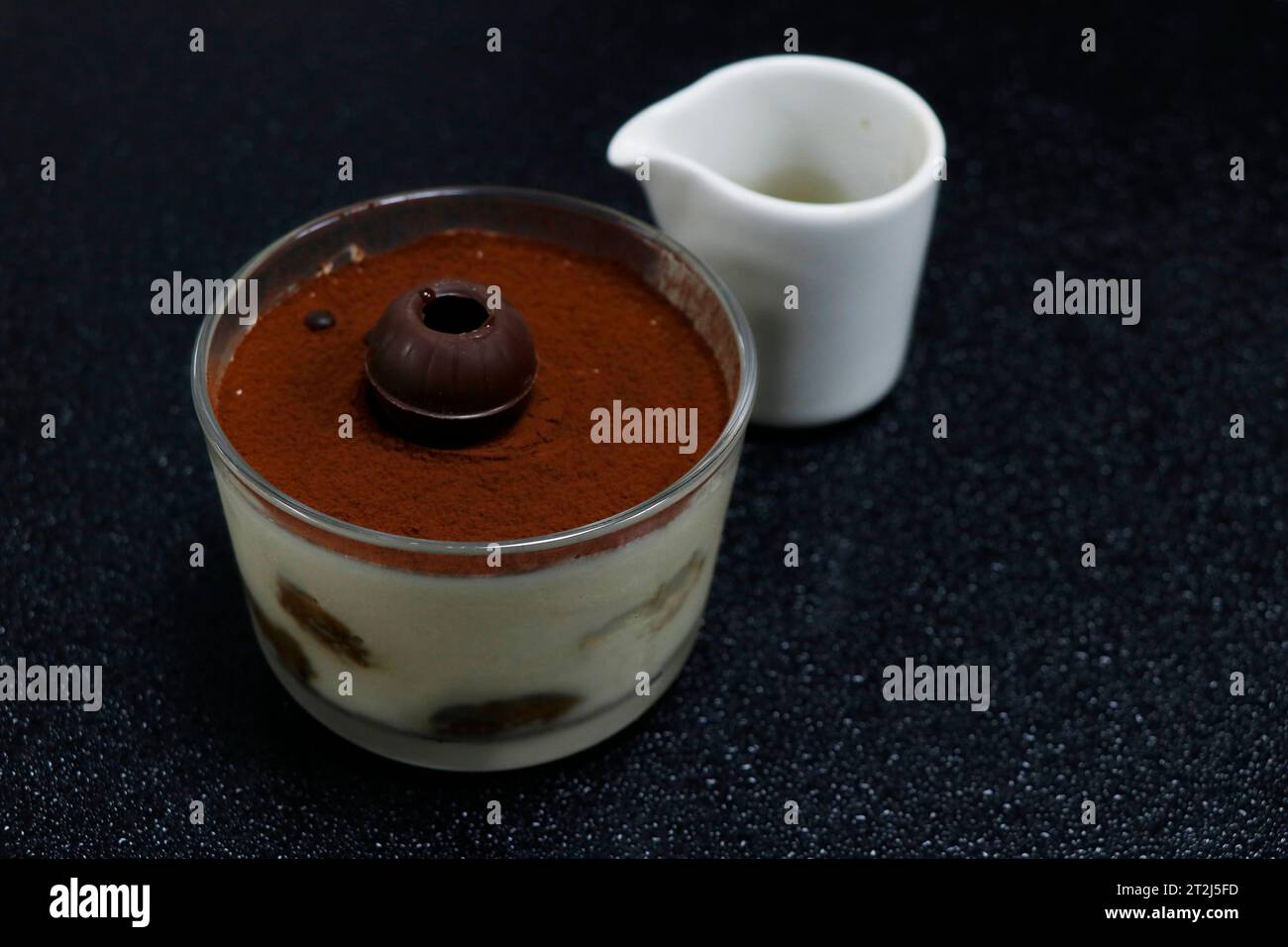 Klassisches italienisches Dessert-Tiramisu auf schwarzem Hintergrund Stockfoto