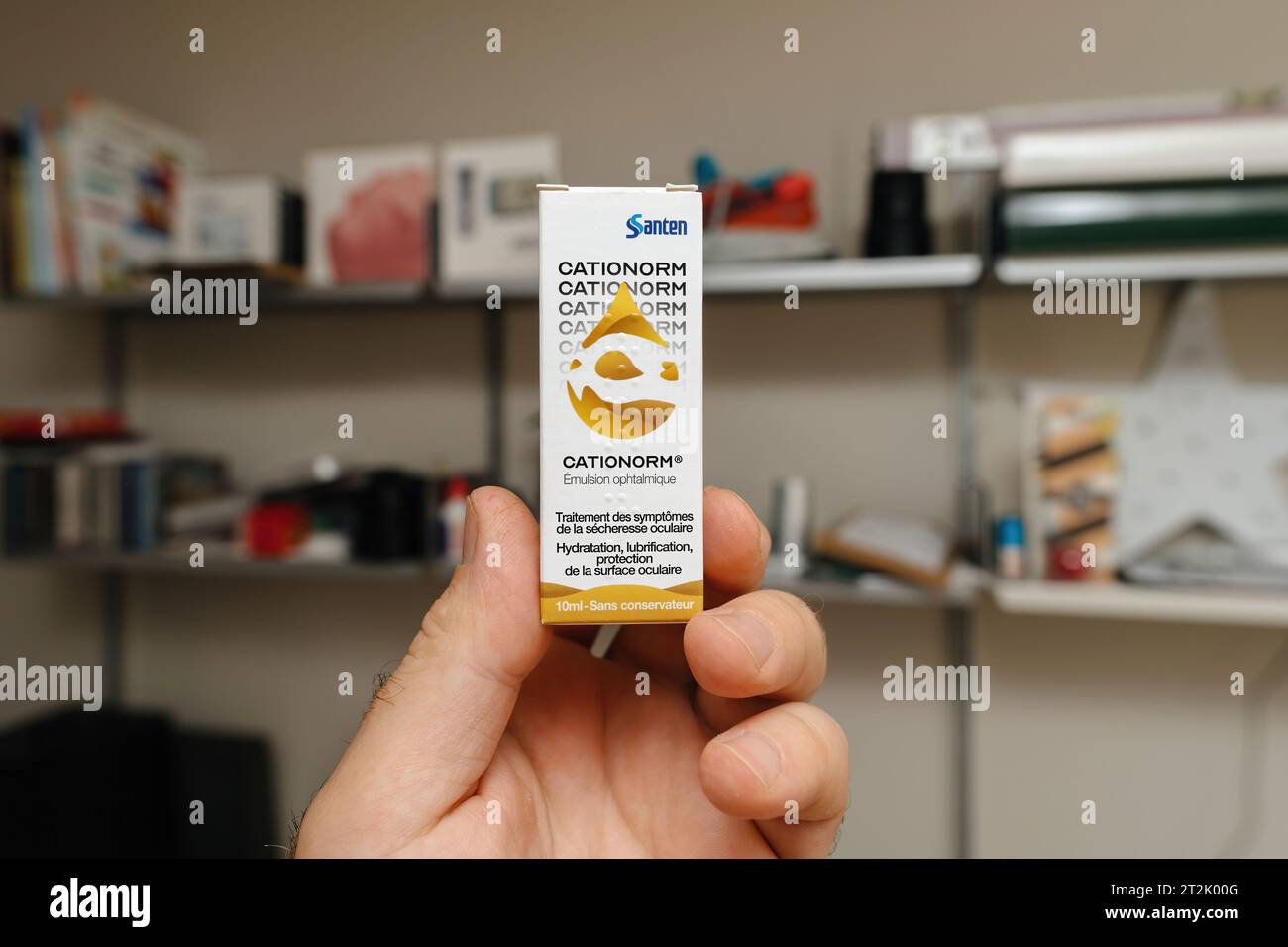 Paris, Frankreich - 30. Mai 2023: Männliche Hand präsentiert in einem Bürozimmer ein Paket Catinorm von Santen, eine ophthalmologische Lösung Stockfoto