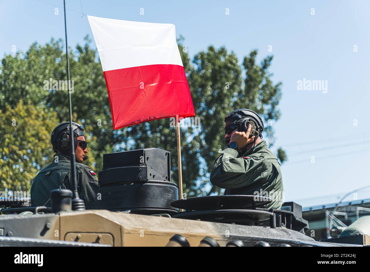 16.08.2023 Warschau, Polen. Zwei Soldaten tragen Militärhelme mit Kopfhörern und polnischer Flagge, die dazwischen flattert. Polen und seine Streitkräfte. Hochwertige Fotos Stockfoto