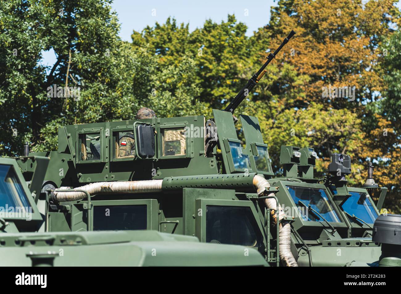 Oberer Teil gepanzerter Militärfahrzeuge gegen grüne und orangene Bäume. Außenaufnahme. Militärparade-Konzept. Hochwertige Fotos Stockfoto