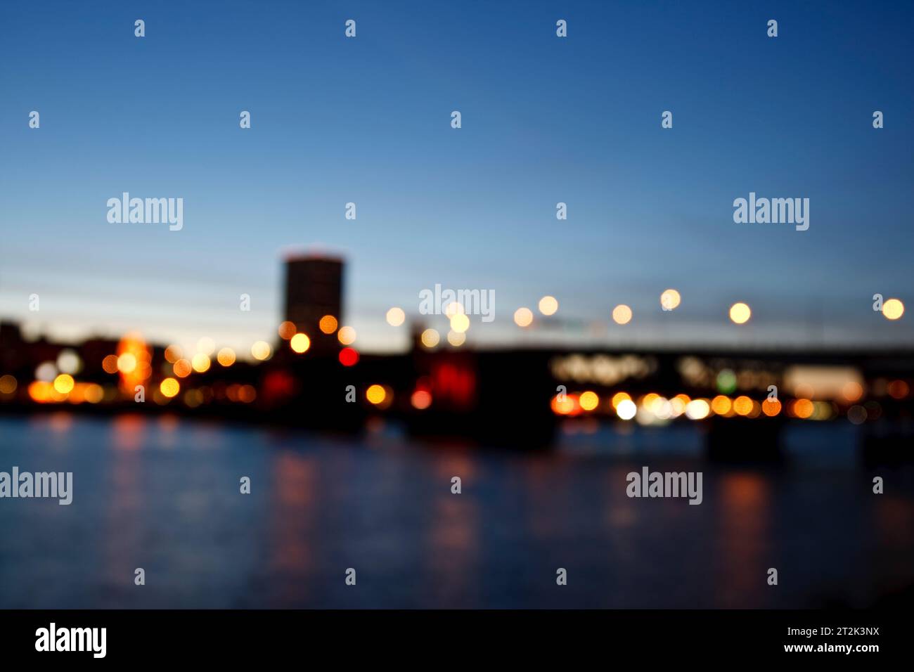 Straßenlaternen leuchten in der Abenddämmerung in einem Bild einer unscharfen Brücke auf. Stockfoto