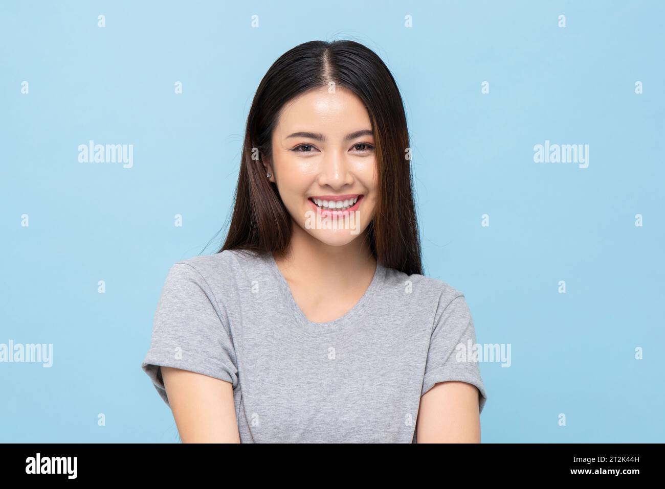 Porträt eines hübschen südostasiatischen Mädchens, das in hellblauer Farbe lächelt Stockfoto
