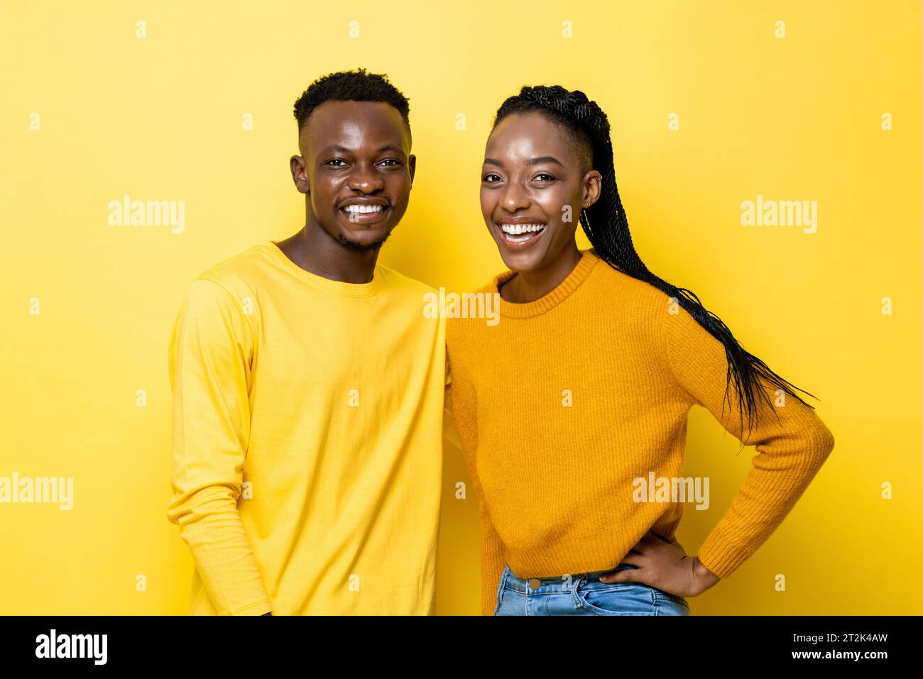 Porträt des positiven afrikanischen Paares, das in einem isolierten gelben Farb-Studio-Hintergrund lächelt Stockfoto