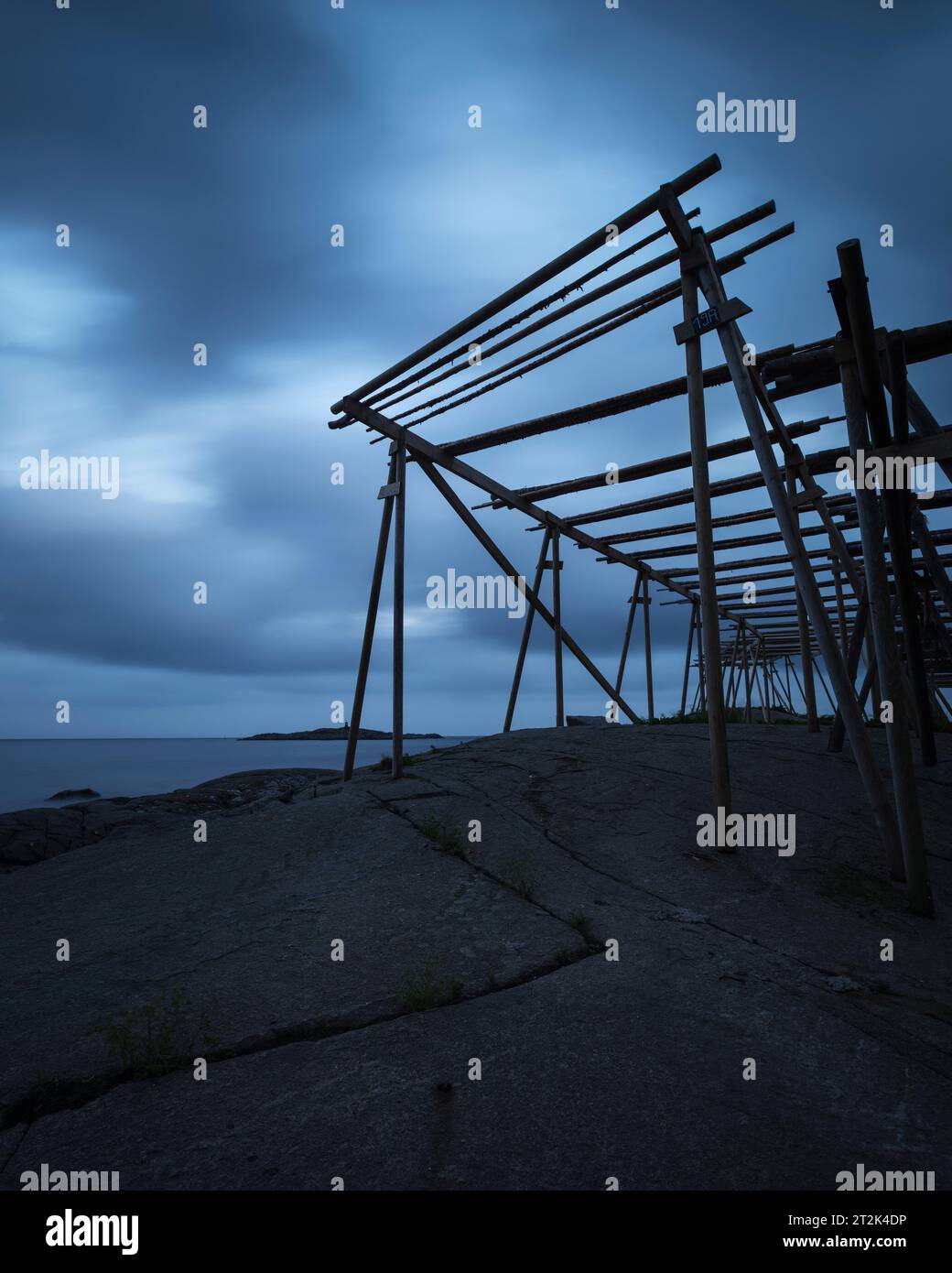 Leere Trockenregale für Kabeljaustockfische erheben sich in einen dunklen Himmel, reine, MoskenesÃ¸y, Lofoten-Inseln, Norwegen Stockfoto
