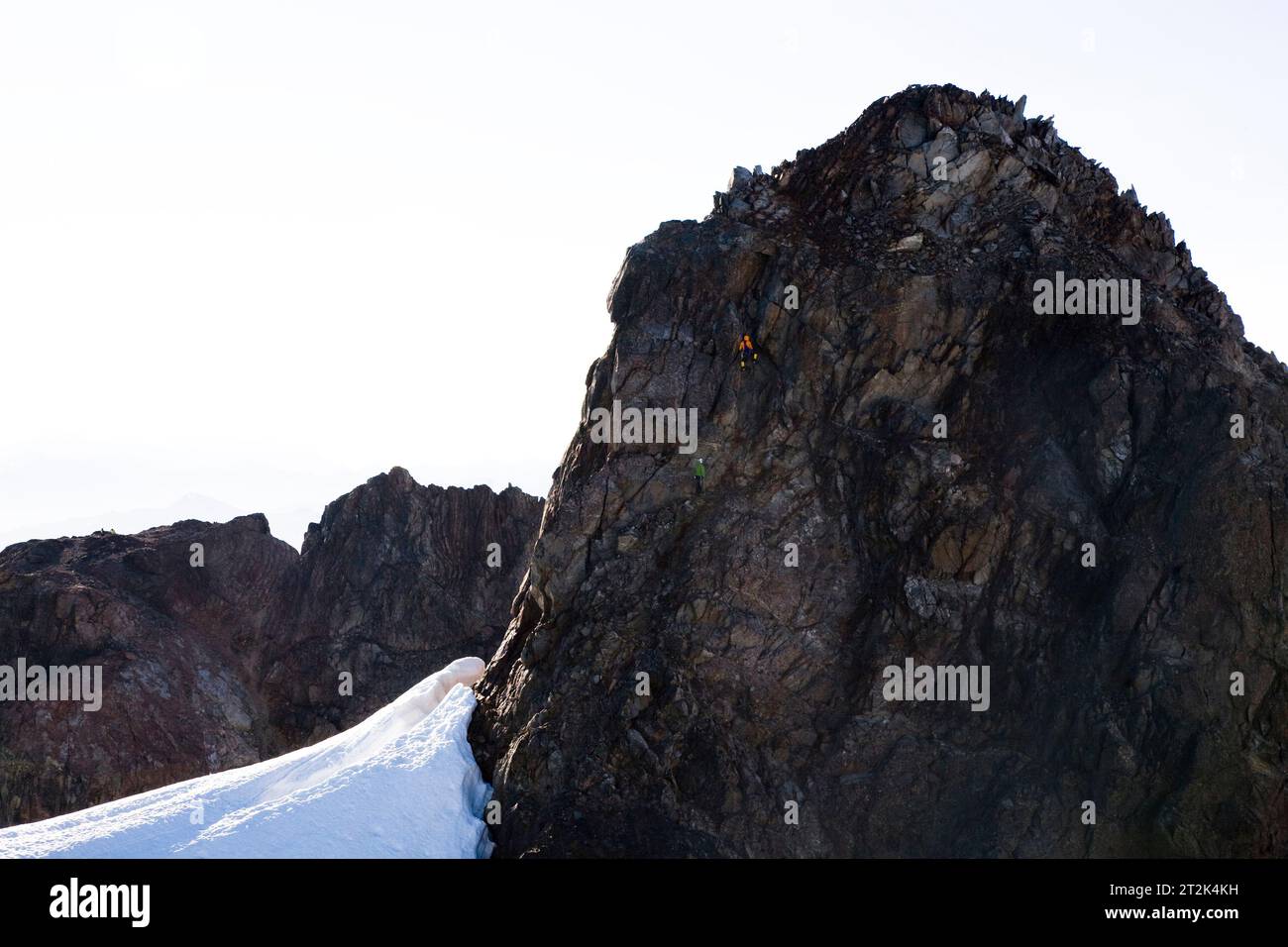Zwei Bergsteiger erklimmen den Gipfelblock des Mt. Olymp auf der Olympischen Halbinsel, WA. Stockfoto