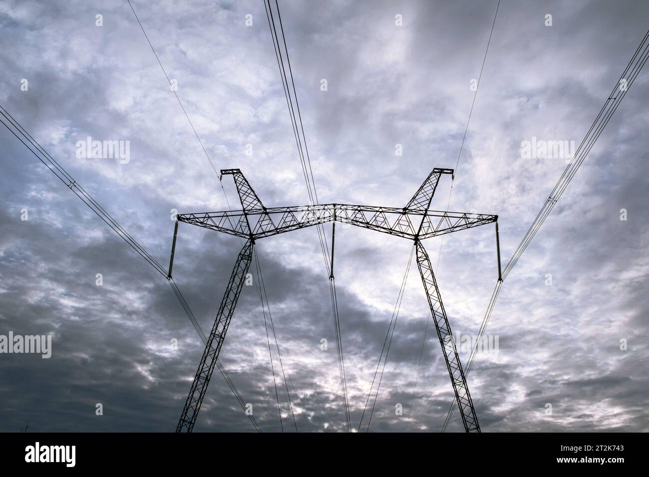 Hochspannungspol gegen graue Wolken. Stockfoto