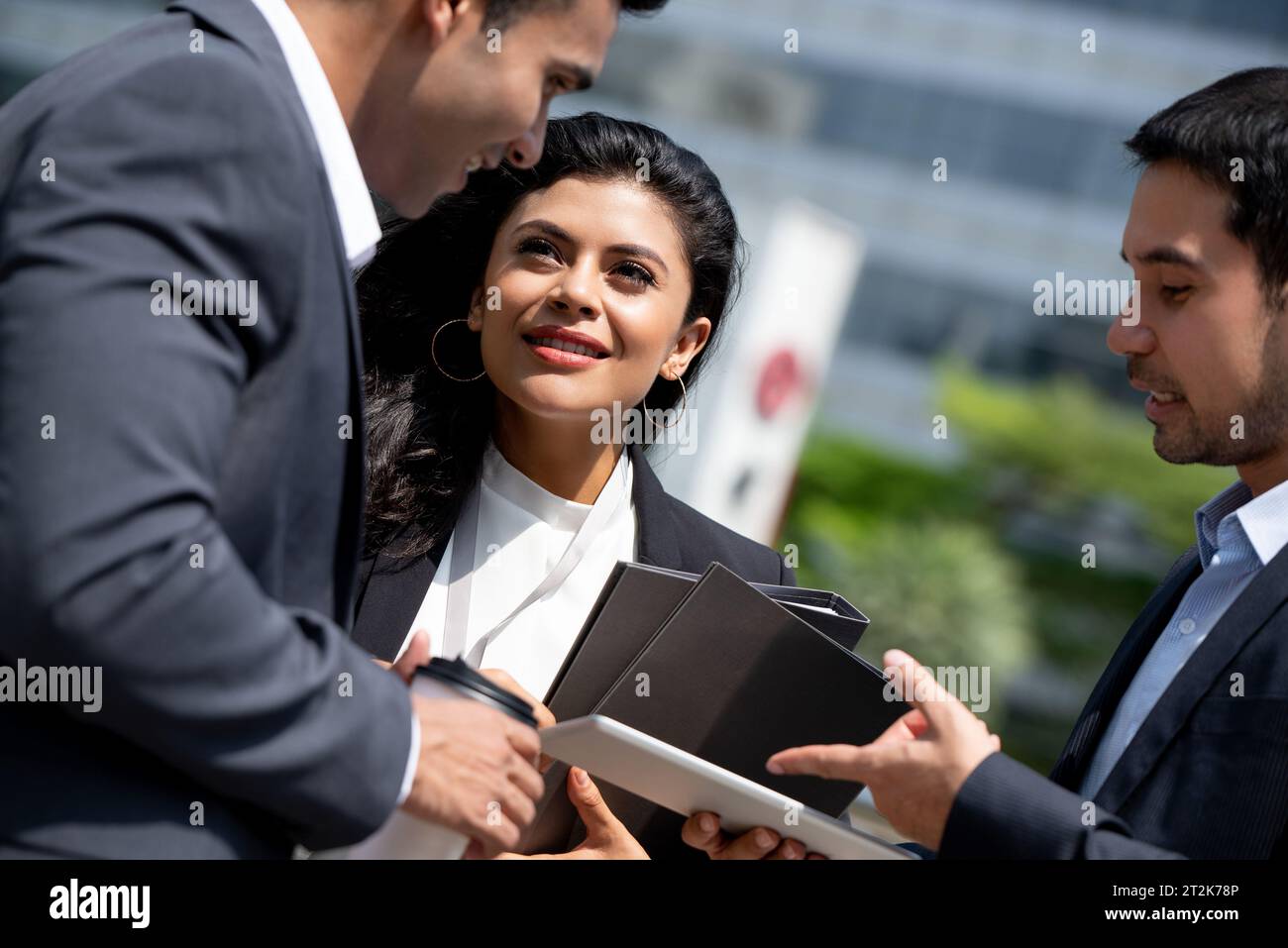 Asiatisches Business-Team in Firmenkleidung trifft sich und spricht draußen in der Stadt Stockfoto