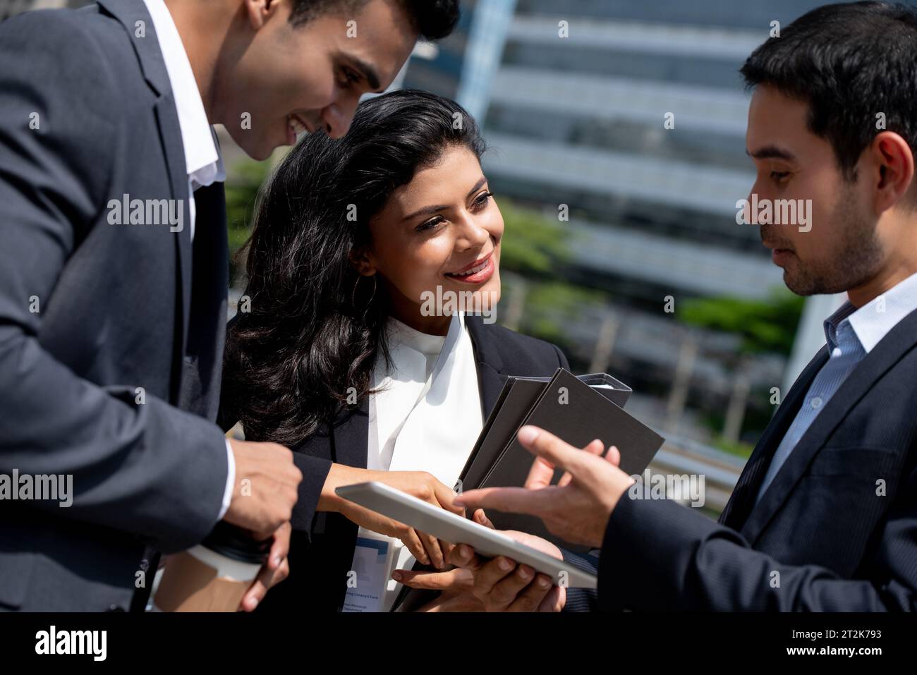 Asiatisches Business-Team in Firmenkleidung trifft sich und spricht draußen in der Stadt Stockfoto
