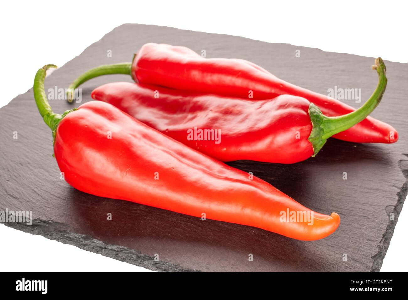 Drei rote Paprika mit Schieferstein Stockfoto