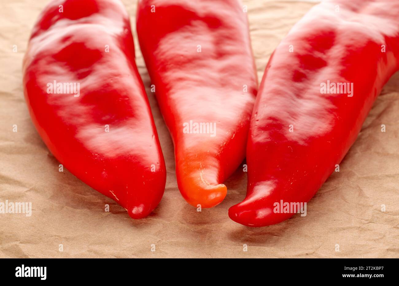 Drei rote Paprika mit Kraftpapier Stockfoto